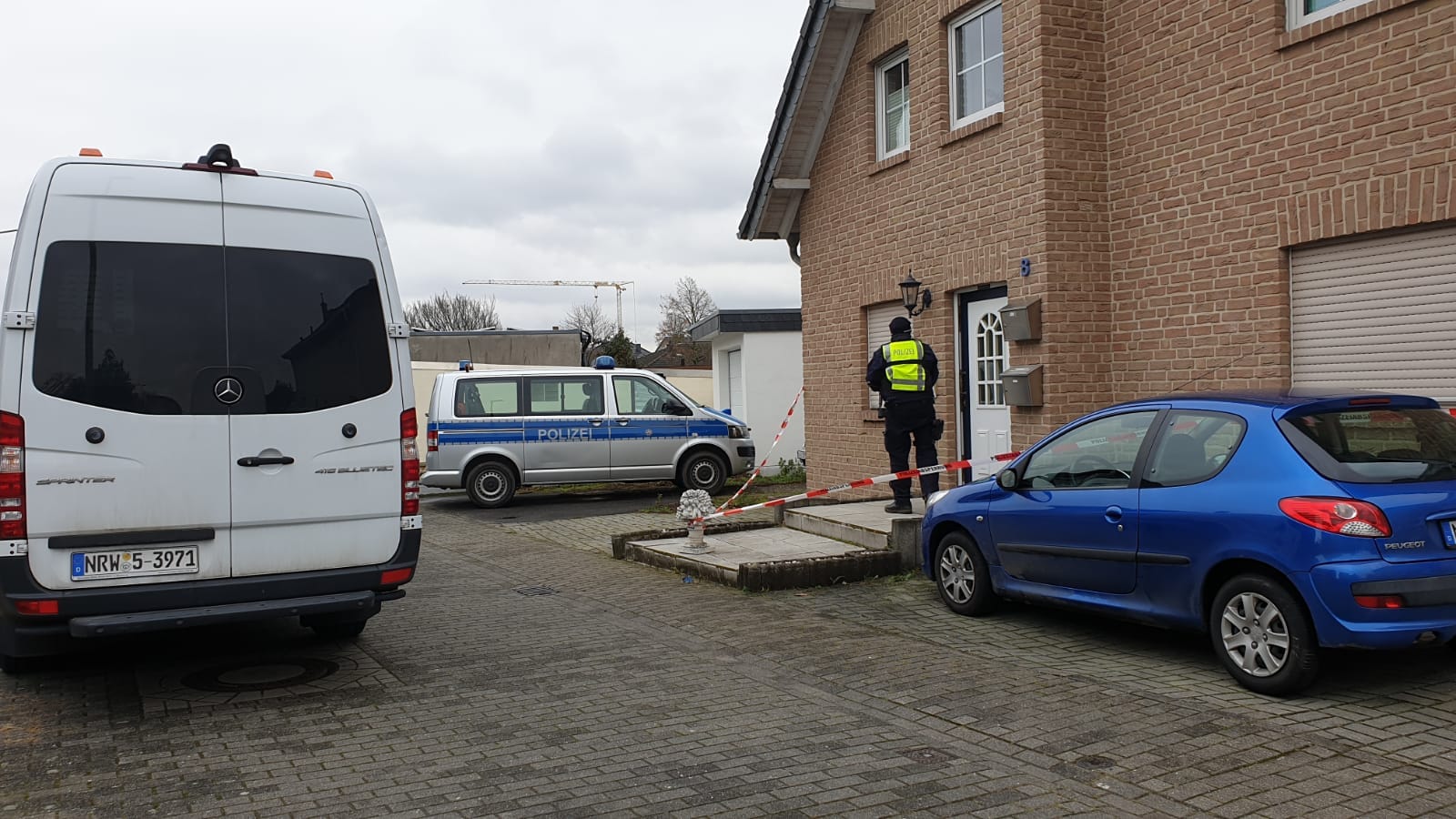 Ein Polizist vor dem Haus, in dem die Leichen gefunden wurden: Es soll sich bei den Toten um drei Erwachsene handeln.