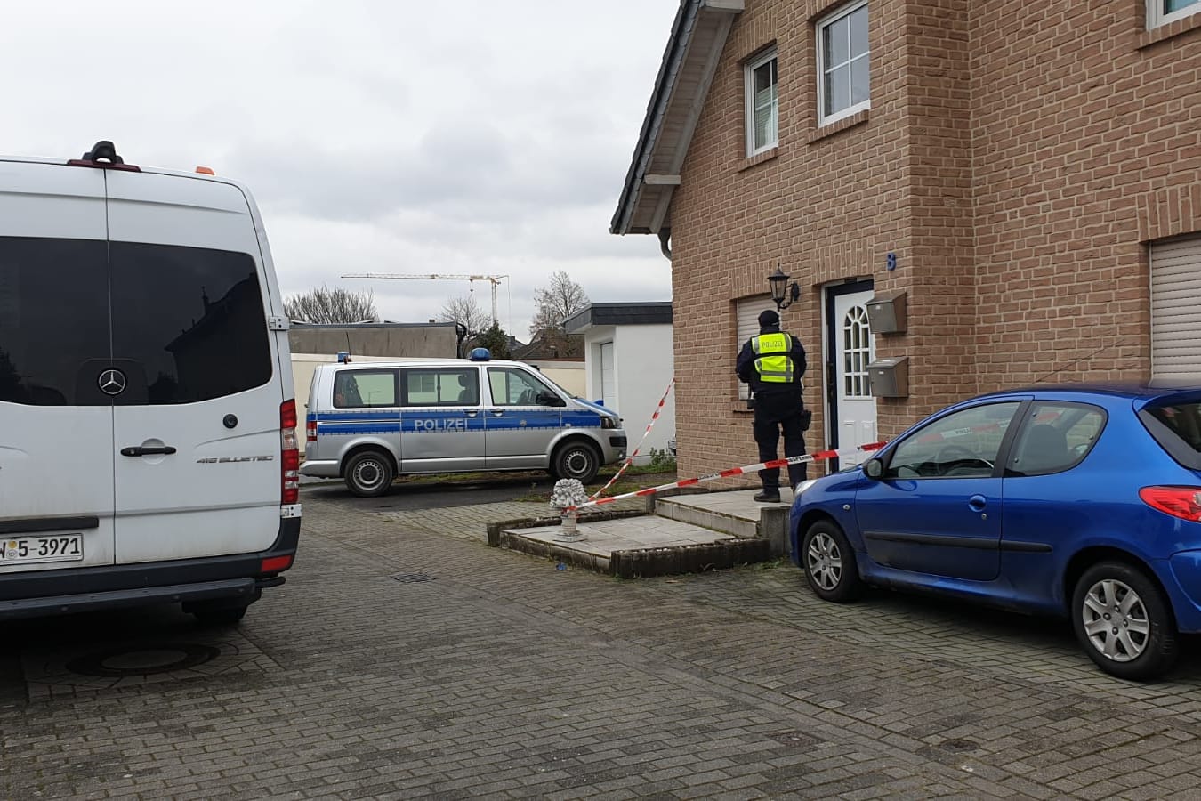 Ein Polizist vor dem Haus, in dem die Leichen gefunden wurden: Es soll sich bei den Toten um drei Erwachsene handeln.