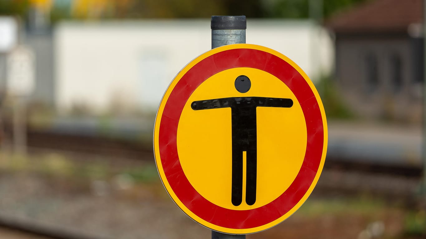 Ein Schild warnt vor einem Bahnhof: Es ist hochgefährlich sich auf Bahngleise zu begeben. (Symbolbild)