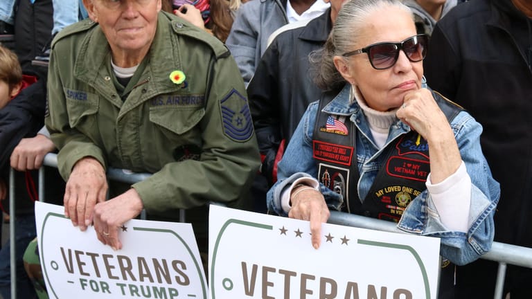 Zuschauer einer Parade halten Schilder: "Veteranen für Trump"