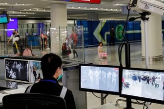 Ein Beamter der Gesundheitsüberwachung überwacht mit Wärmebildkameras die Temperatur von Reisenden am Flughafen von Hongkong ankommenden Reisenden.