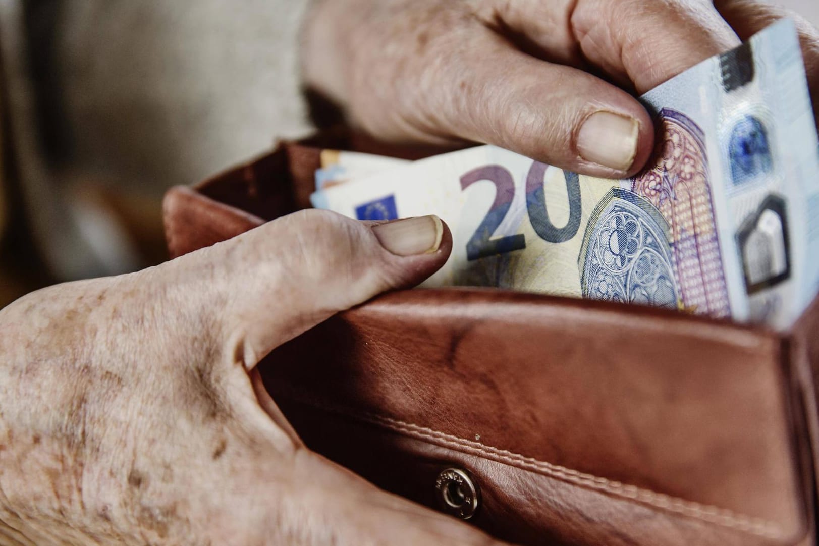 Eine Seniorin zieht einen Geldschein aus ihrem Portemonnaie: Mit Eintritt in das Rentenalter soll der Staat die Starter-Renter dann auszahlen. (Symbolbild)