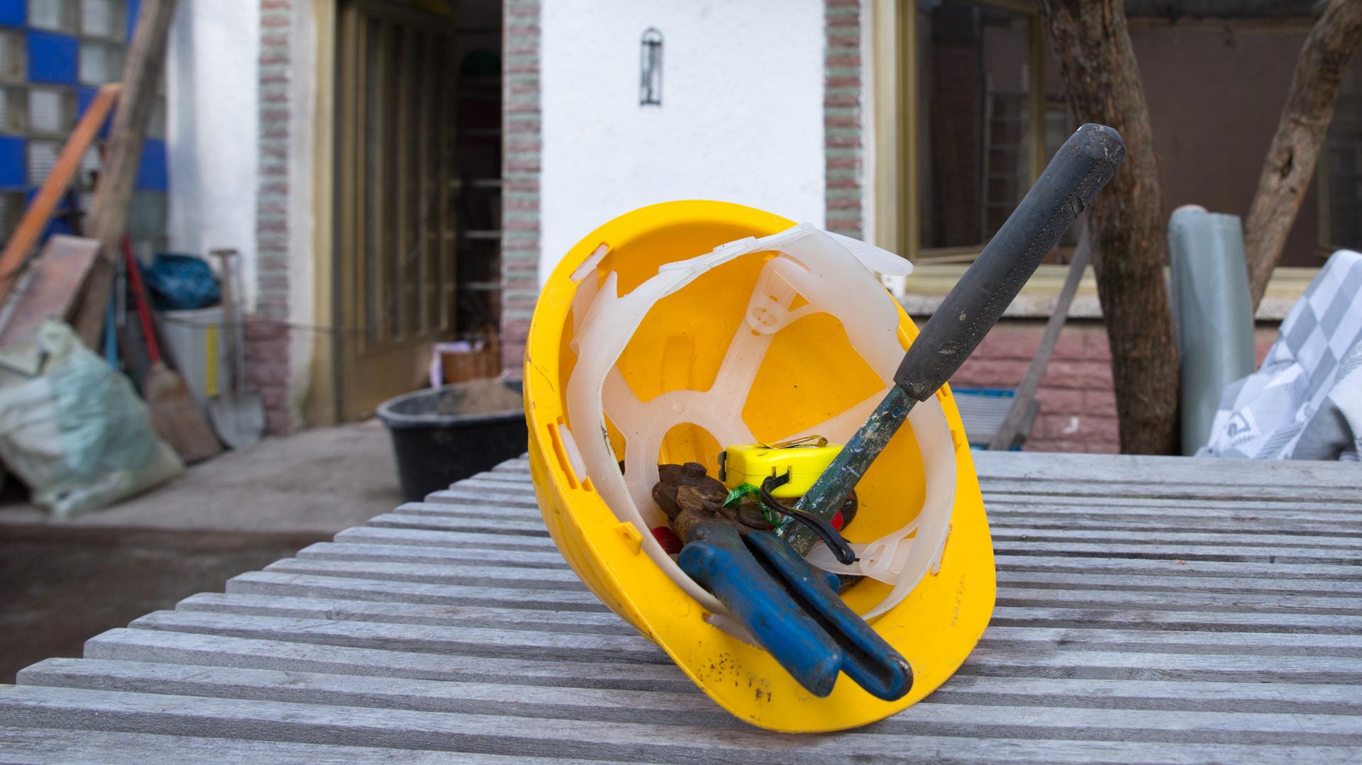 Ein Helm und Werkzeuge: Gibt es keine Aufträge, haben Bauarbeiter nichts zu tun. In einem solchen Fall kann der Arbeitgeber Kurzarbeit anordnen.