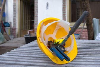 Ein Helm und Werkzeuge: Gibt es keine Aufträge, haben Bauarbeiter nichts zu tun. In einem solchen Fall kann der Arbeitgeber Kurzarbeit anordnen.