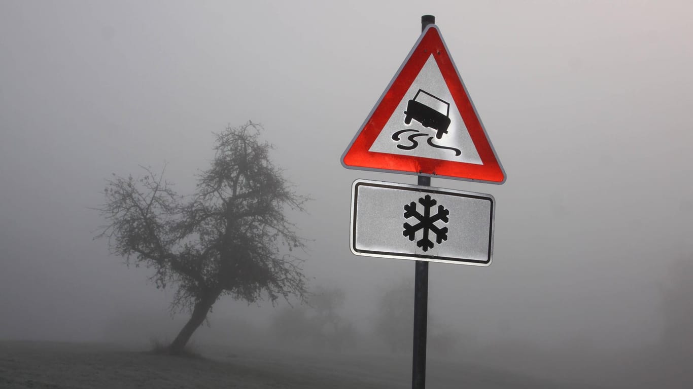 Ein Schild im Nebel warnt vor Glatteis: Am Dienstag sollten Autofahrer besonders vorsichtig unterwegs sein. (Symbolbild)