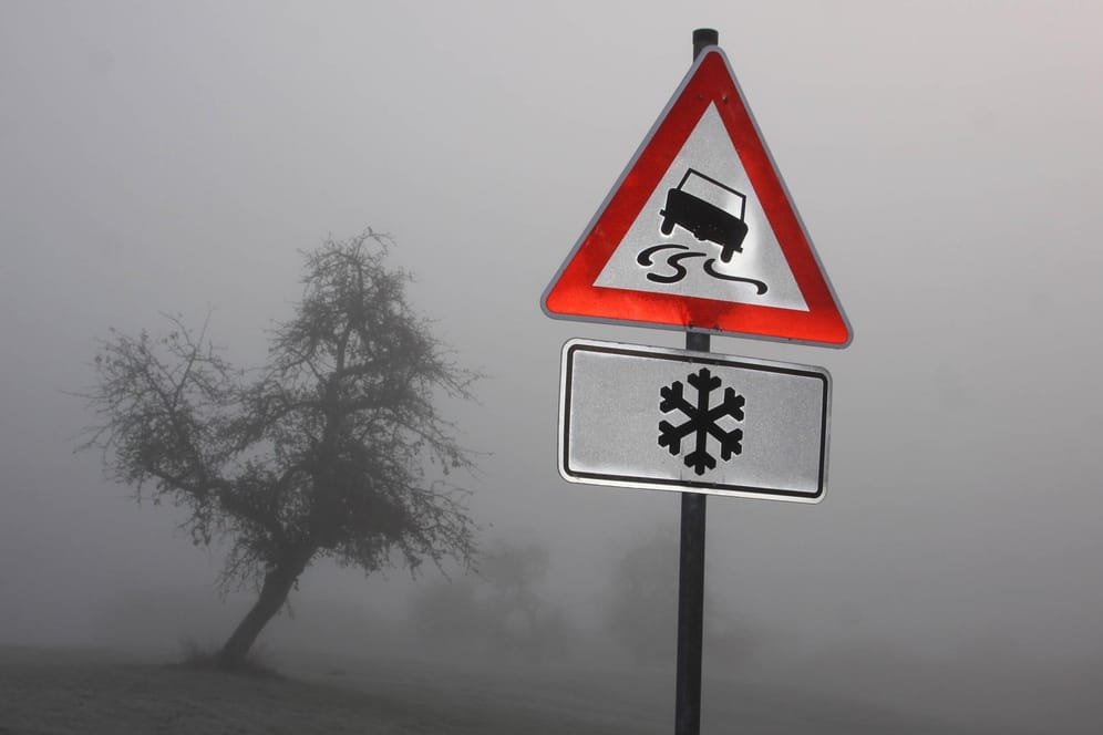 Ein Schild im Nebel warnt vor Glatteis: Am Dienstag sollten Autofahrer besonders vorsichtig unterwegs sein. (Symbolbild)