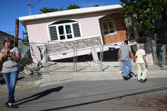 Anwohner betrachten ein Haus, das nach einem Erdbeben in Guanica teilweise eingestürzt ist: Behörden ließen die Küste der Insel vorsorglich evakuieren.