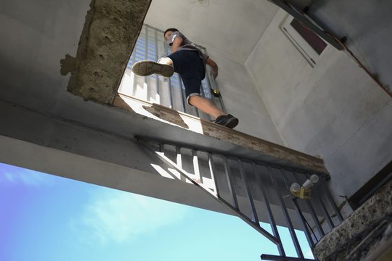 Ein Junge klettert durch das beschädigte Haus seiner Tante, das nach einem Erdbeben teilweise eingestürzt ist.