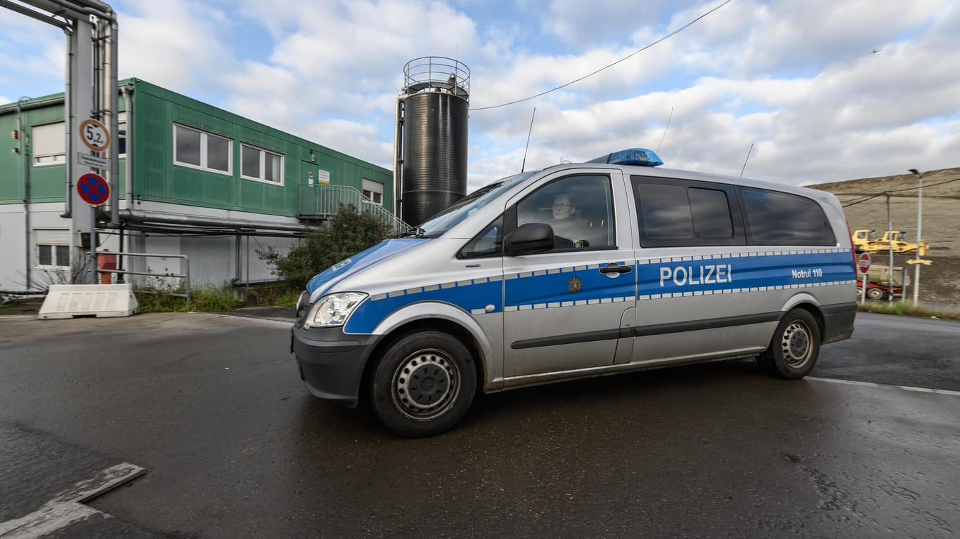 Polizisten fahren mit einem Streifenwagen auf dem Gelände des Rhein-Main-Deponieparks: Die Ermittler suchen in verbrannten Müllresten nach einer vermissten Frau.