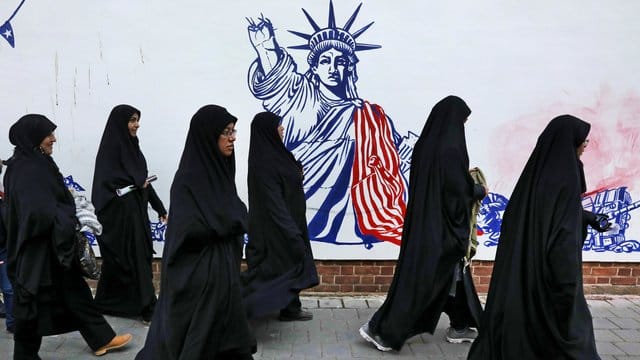 Die Teilnehmerinnen einer Trauerzeremonie für den getöteten General Soleimani gehen auf ihrem Heimweg an der satirischen Zeichnung einer verstümmelten Freiheitsstatue vorbei. Die Teilnehmerinnen einer Trauerzeremonie für den getöteten General Soleimani gehen auf ihrem Heimweg an der satirischen Zeichnung einer verstümmelten Freiheitsstatue vorbei.