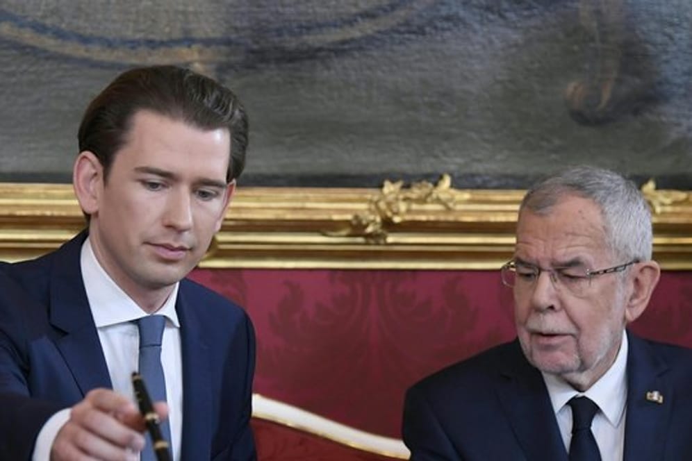Sebastian Kurz, Bundeskanzler von Österreich, unterzeichnet seine Ernennungsurkunde neben Bundespräsident Alexander Van der Bellen.