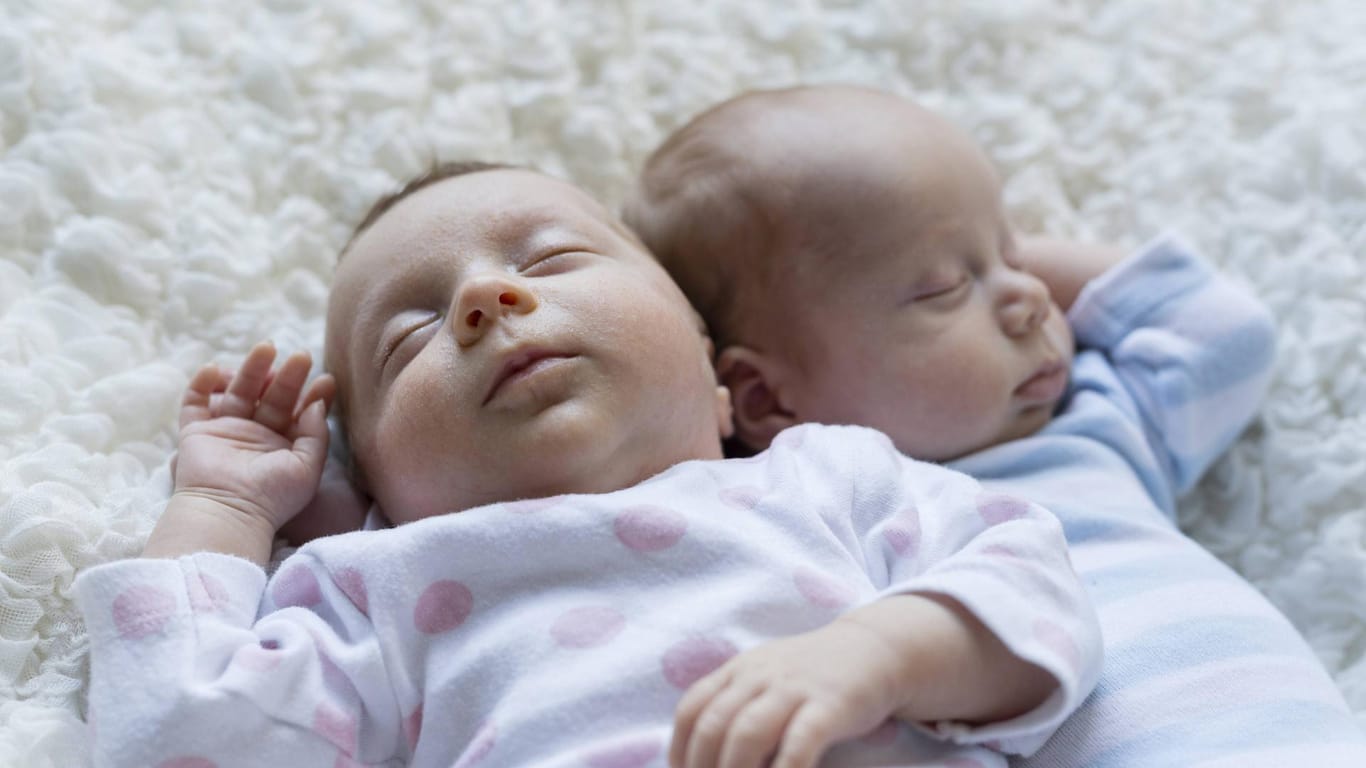 Ein Zwillingspärchen schläft auf einer Decke: In Köln sind in einem Krankenhaus im Jahr 2019 besonders viele Zwillinge und Drillinge geboren worden (Symbolbild).