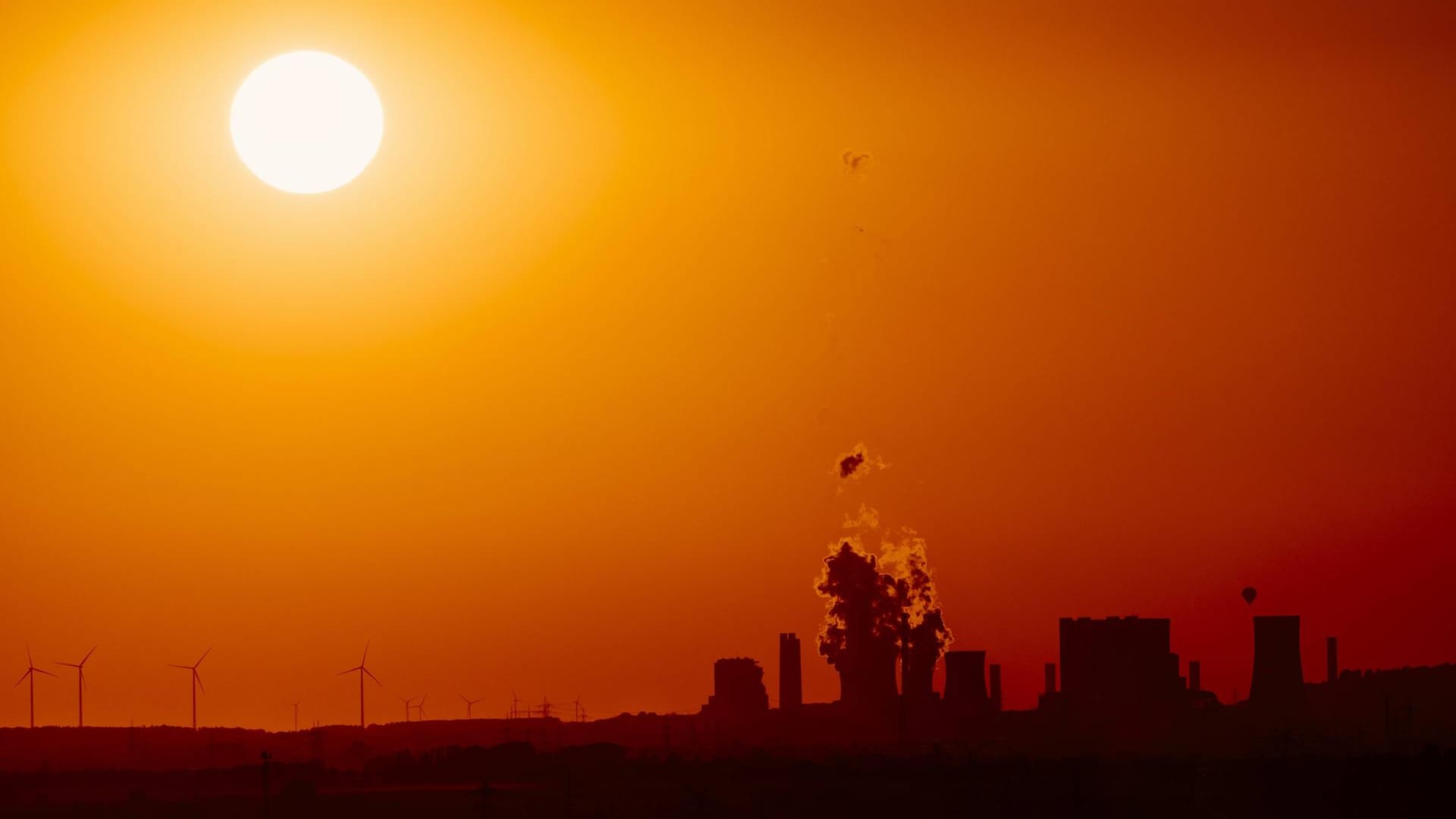 Ein deutsches Braunkohlekraftwerk und Windkraftanlagen am Horizont: Die Frage der Energiegewinnung ist entscheidend für die Zukunft des Erdklimas. (Symbolbild)