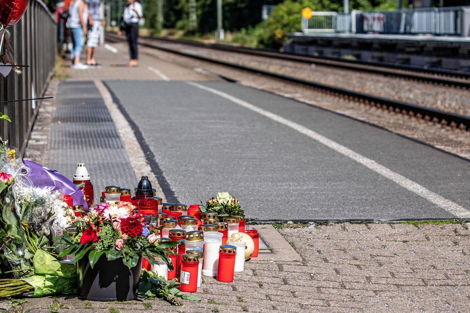 Blumen und Kerzen in Voerde am Bahnhof: Eine Frau starb, nachdem ein Mann sie vor einen einfahrenden Zug geschubst hatte. (Archivbild)