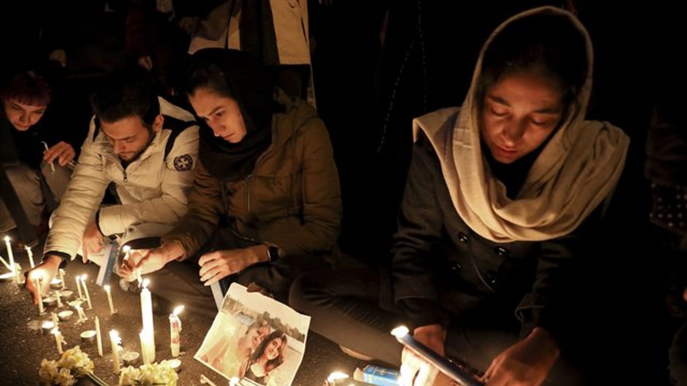 Menschen zünden bei einer Mahnwache am Eingang der Amri Kabir Universität in Teheran Kerzen an, um der Opfer des Flugzeugabsturzes zu gedenken.