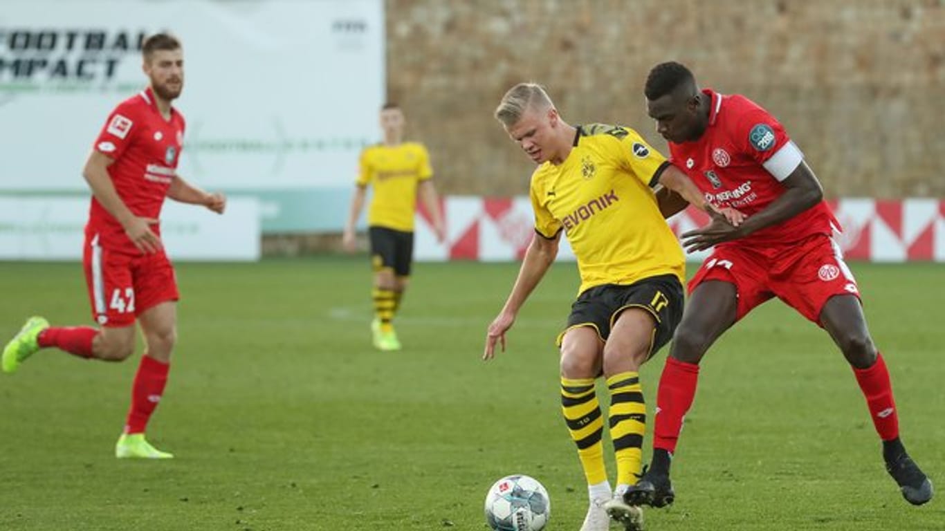 Dortmunds Neuzugang Erling Haaland (M) im Zweikampf mit dem Mainzer Moussa Niakhate.
