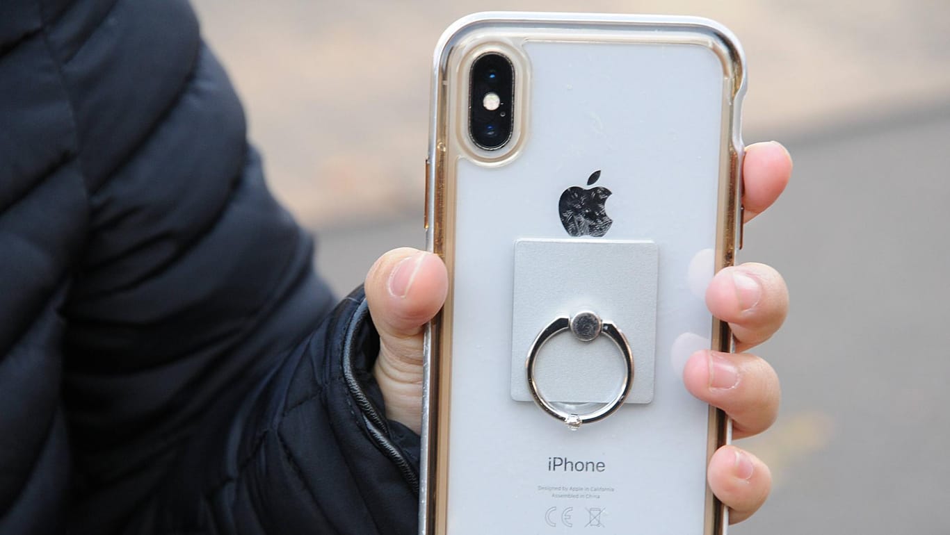 Ein Mann zeigt die Hülle seines iPhones: Apple ruft die smarten Ladehüllen für das iPhone XS zurück.
