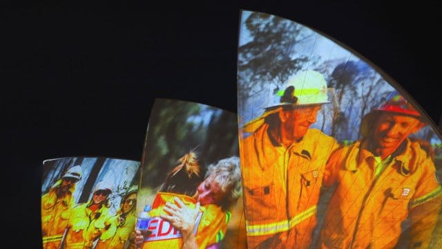 Symbolischer Dank an die Einsatzkräfte in Sydney: Auf die großen Segel des Opernhauses werden als Zeichen der Solidarität Bilder von Feuerwehrleuten projiziert. Symbolischer Dank an die Einsatzkräfte in Sydney: Auf die großen Segel des Opernhauses werden als Zeichen der Solidarität Bilder von Feuerwehrleuten projiziert.