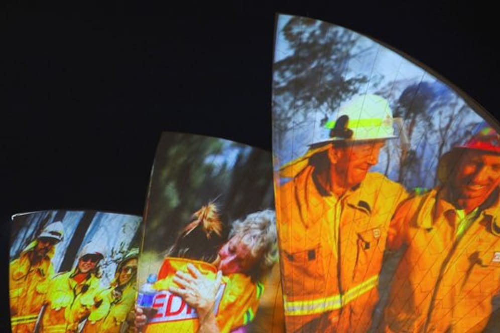 Symbolischer Dank an die Einsatzkräfte in Sydney: Auf die großen Segel des Opernhauses werden als Zeichen der Solidarität Bilder von Feuerwehrleuten projiziert.