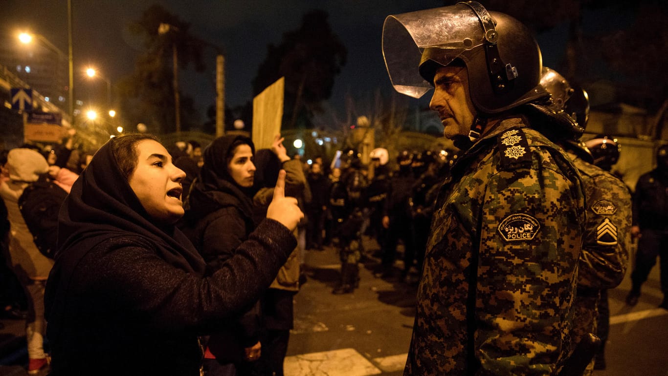 Teheran am Samstagabend: Eine Frau spricht bei einer Trauerkundgebung vor der Amir-Bakir-Universität mit einem Polizisten.