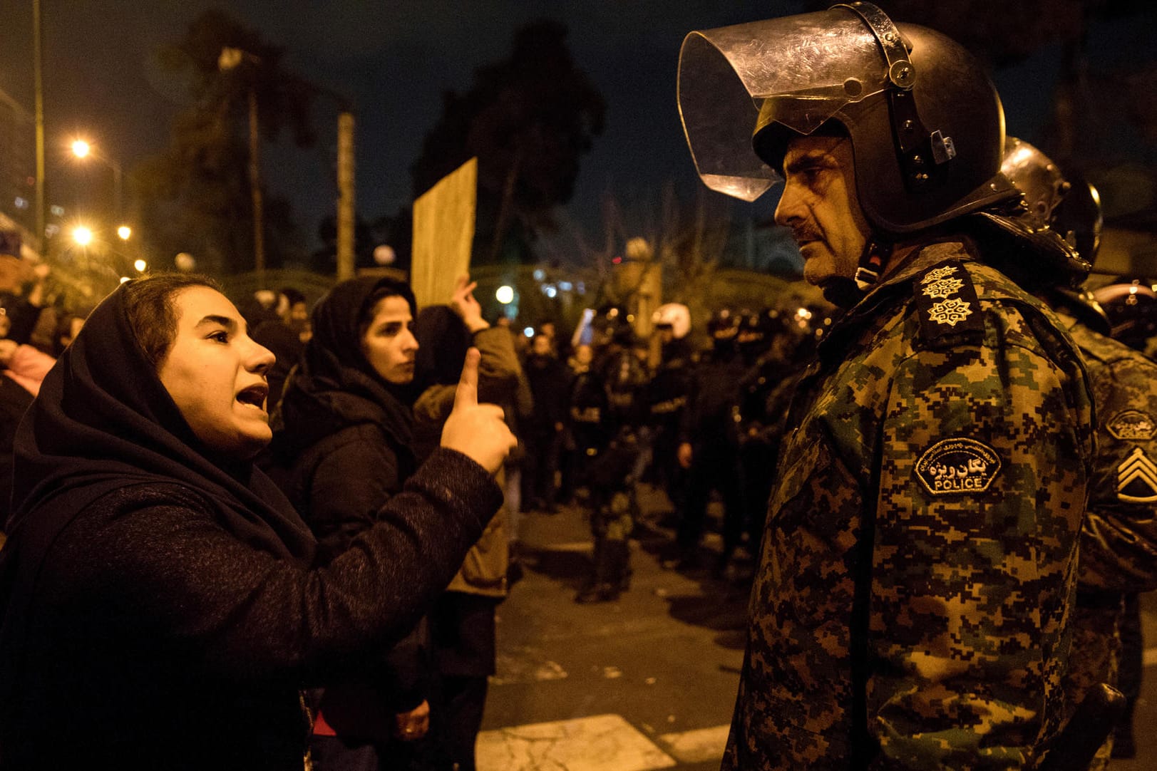 Teheran am Samstagabend: Eine Frau spricht bei einer Trauerkundgebung vor der Amir-Bakir-Universität mit einem Polizisten.
