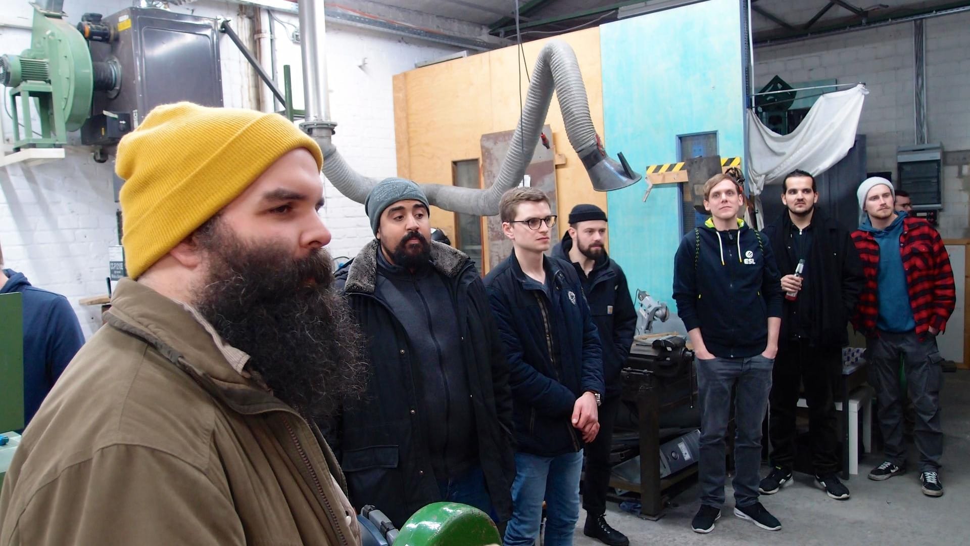 Menschen laufen durch eine Gewerbehalle: Felix Dietz führt interessierte Gäste durch die Räume der "DingFabrik", hier die Metallwerkstatt.