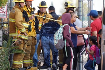 Feuerwehrmänner gewähren Eltern den Zugang: Ein Flugzeug hat wegen eines Triebwerkproblems Treibstoff über dem Spielplatz abgelassen.