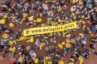 Sportler des TuS Holsterhausen in Essen halten ein Banner hoch: Der Verein fordert, den Bolzplatz nebenan künftig nutzen zu dürfen.