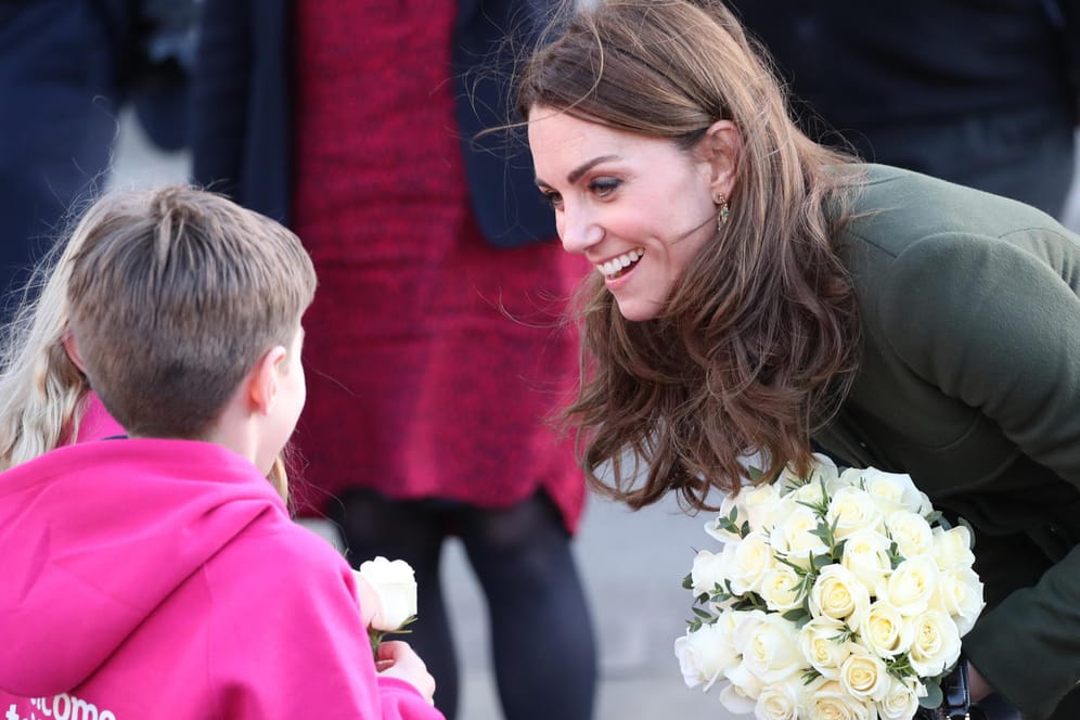 Die Herzogin von Cambridge: Kate spricht nach dem Besuch des Rathauses von Bradford, wo sie sich mit Jugendlichen traf, um mehr über das Leben in der Stadt zu erfahren, mit Kindern, von denen sie eine weiße Rose überreicht bekommt.
