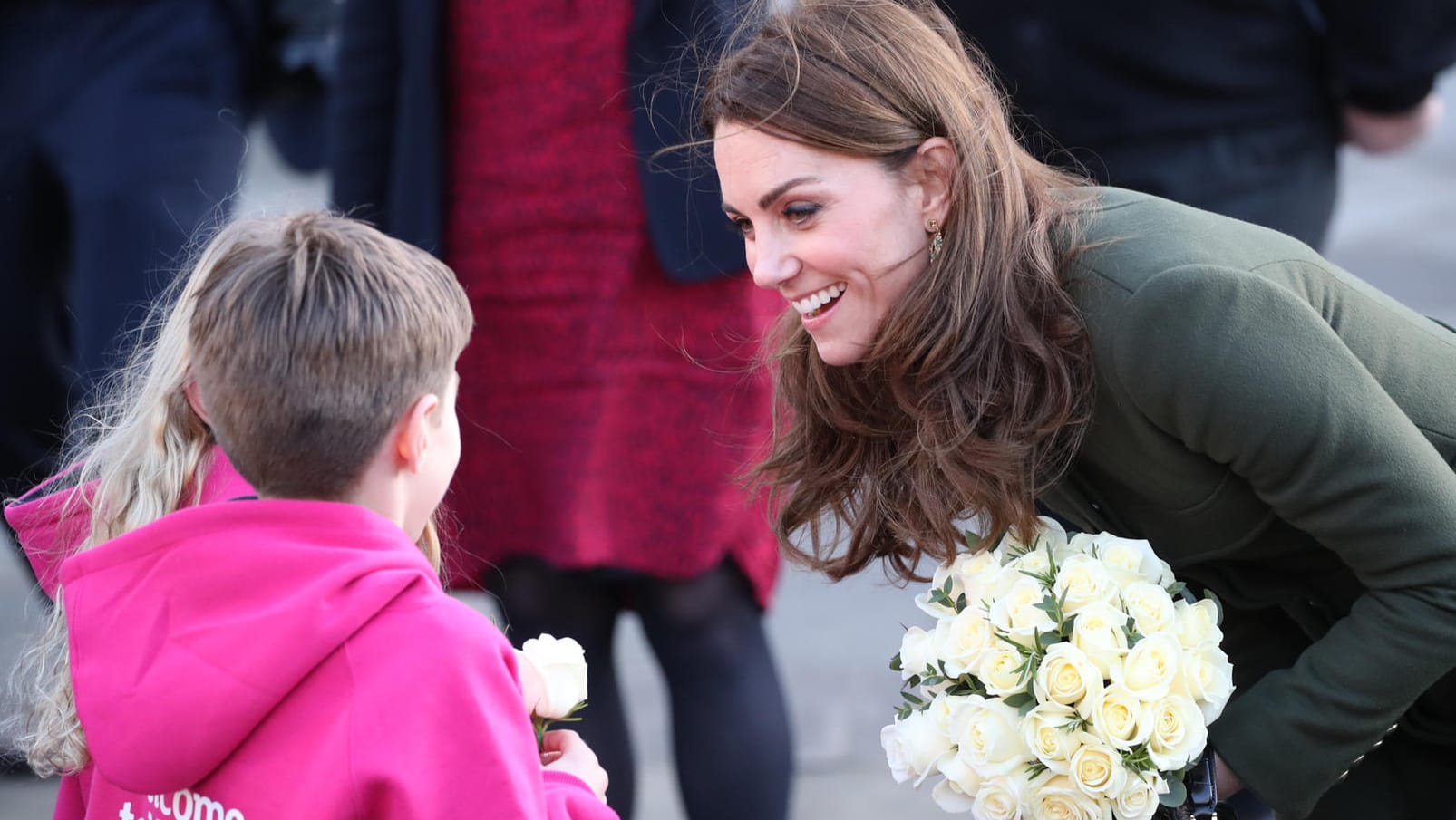 Die Herzogin von Cambridge: Kate spricht nach dem Besuch des Rathauses von Bradford, wo sie sich mit Jugendlichen traf, um mehr über das Leben in der Stadt zu erfahren, mit Kindern, von denen sie eine weiße Rose überreicht bekommt.