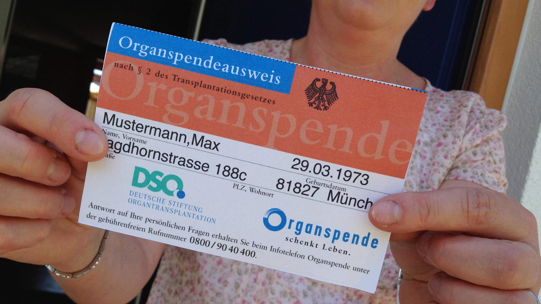 Frau hält Organspendeausweis