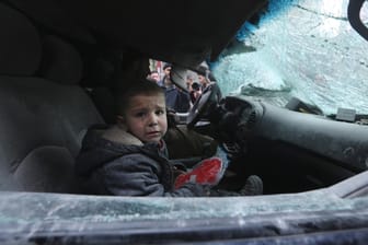 Ein Junge sitzt weinend im Auto: Mindestens 18 Menschen starben bei Luftangriffen.