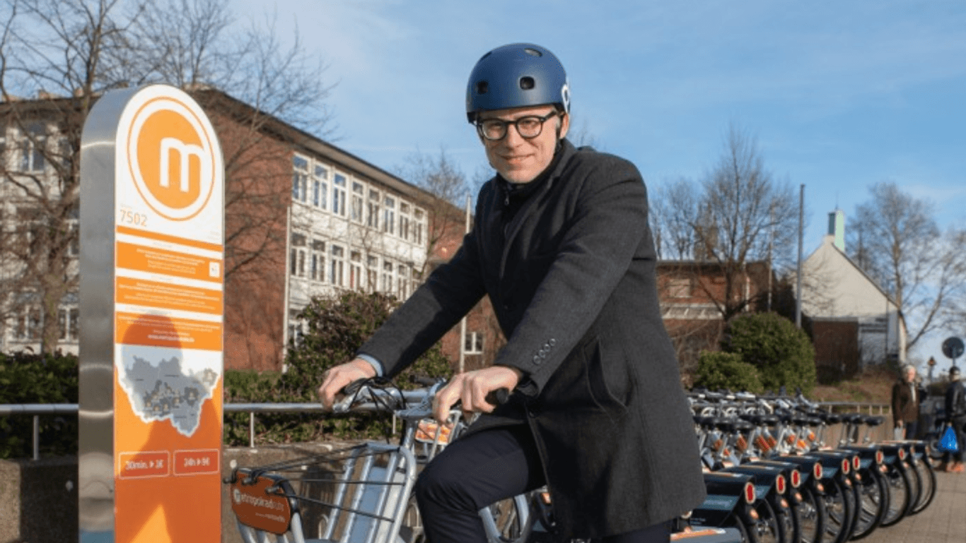 Martin Hartner, Beigeordneter für Stadtplanung, sitzt auf einem neuen Mietrad von metropolruhr.