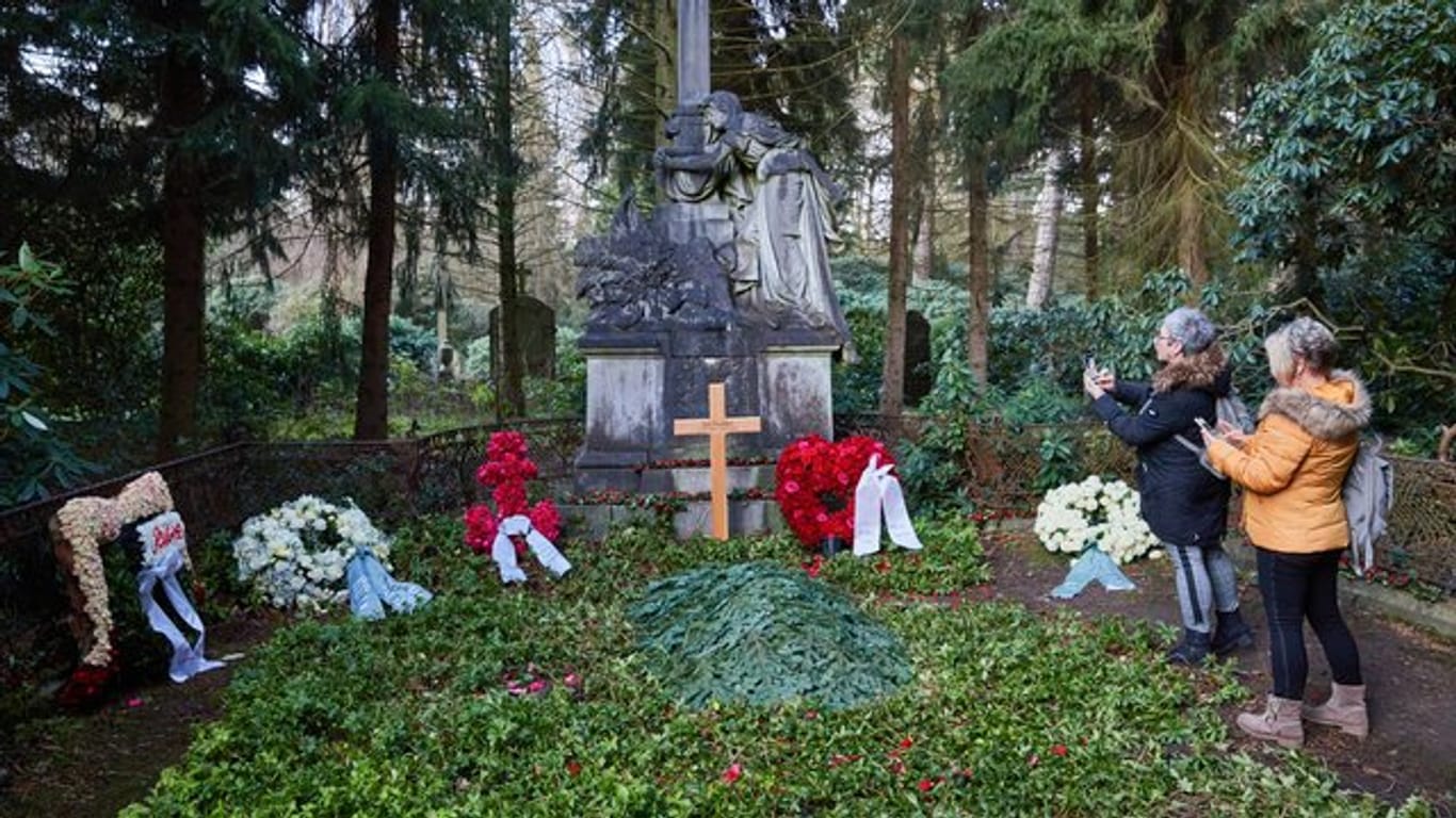 Zwei Frauen stehen am Grab von Jan Fedder auf dem Ohlsdorfer Friedhof.