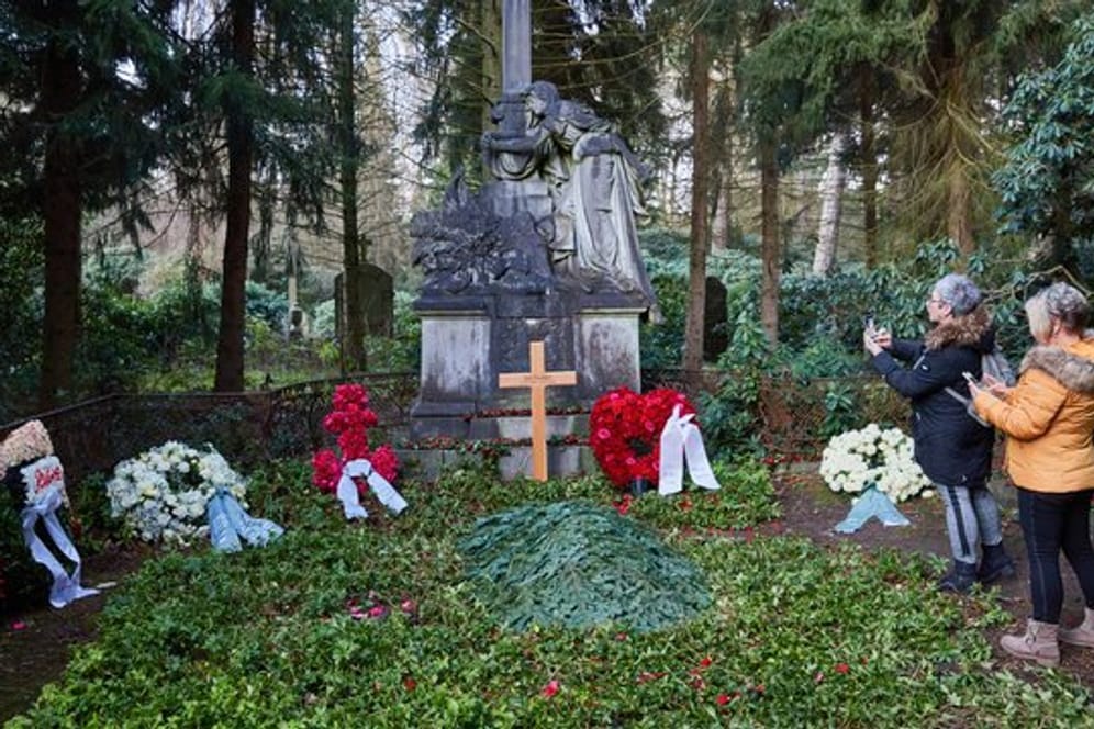 Zwei Frauen stehen am Grab von Jan Fedder auf dem Ohlsdorfer Friedhof.
