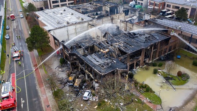 Die Feuerwehr löscht eine ausgebrannte Lagerhalle nach einem Großbrand in der Nacht.