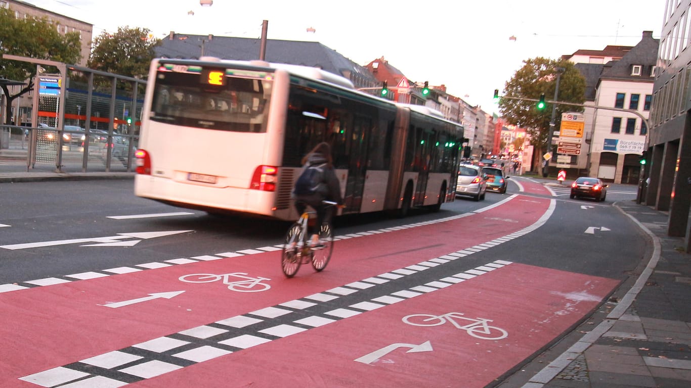 Ein Bus und ein Radfahrer in Darmstadt: Für Autofahrer könnte innerorts künftig Tempo 30 gelten.