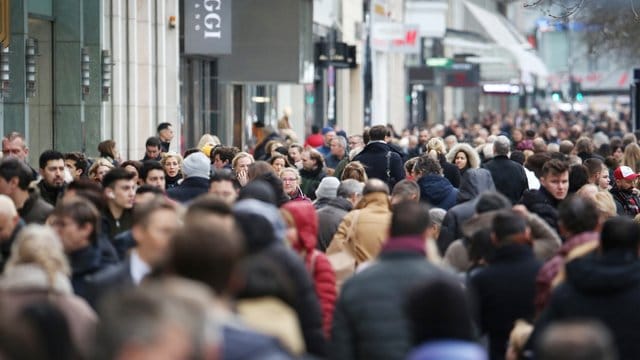 Dicht gedrängt laufen Menschen über die Königsallee in Düsseldorf.