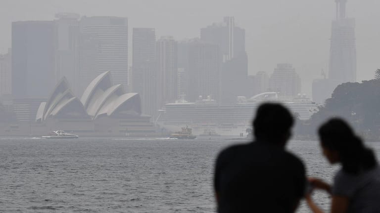 Brotzeit in dichtem Rauch vor der berühmten Oper von Sydney: Vor allem Urlauber aus den USA, Großbritannien und anderen Teilen Europas bleiben weg.