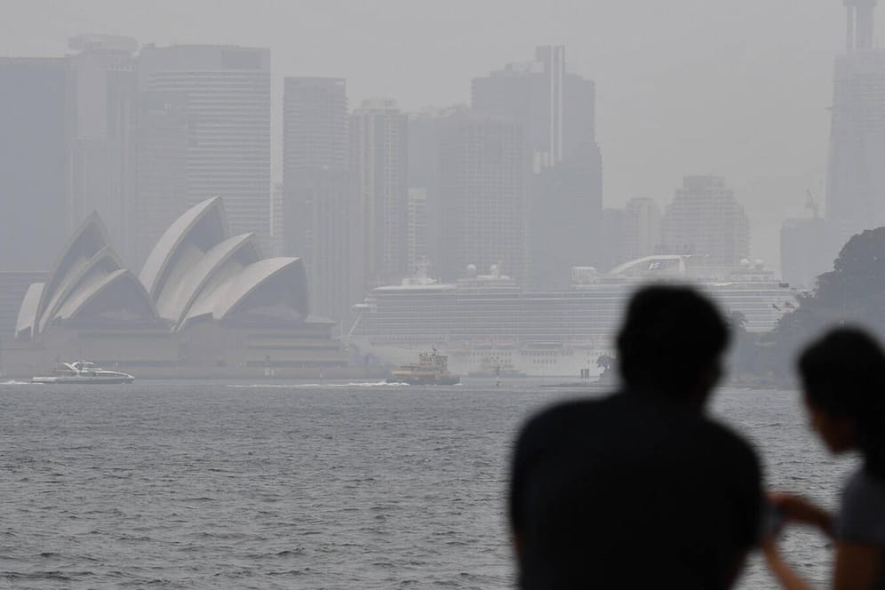 Brotzeit in dichtem Rauch vor der berühmten Oper von Sydney: Vor allem Urlauber aus den USA, Großbritannien und anderen Teilen Europas bleiben weg.