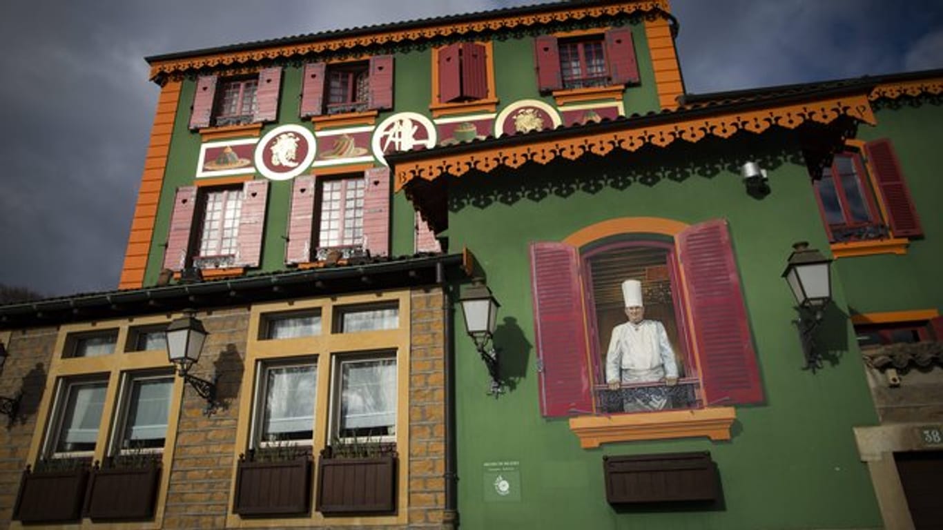 Ein Wandgemälde von Paul Bocuse schmückt die Fassade des Gourmet-Restaurants "L'Auberge du Pont de Collonges".