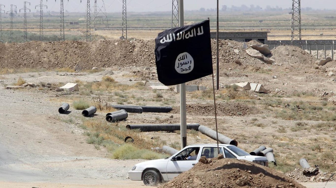 Die Flagge des IS an einer Straße im Irak (Symbolbild): Die Terrormiliz hat weiterhin viele Schläferzellen und Funktionäre, die versteckt leben.