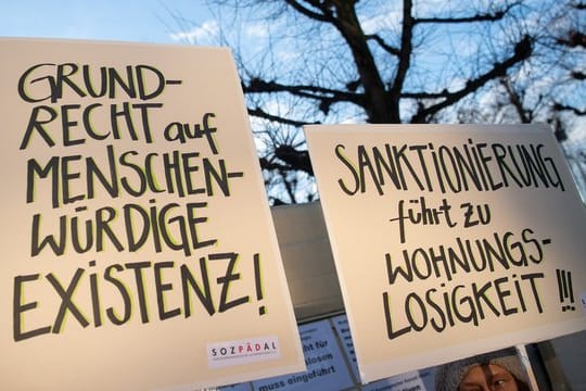 Demonstranten stehen während der Verhandlung über die Rechtmäßigkeit von Hartz-IV-Sanktionen vor dem Bundesverfassungsgericht.