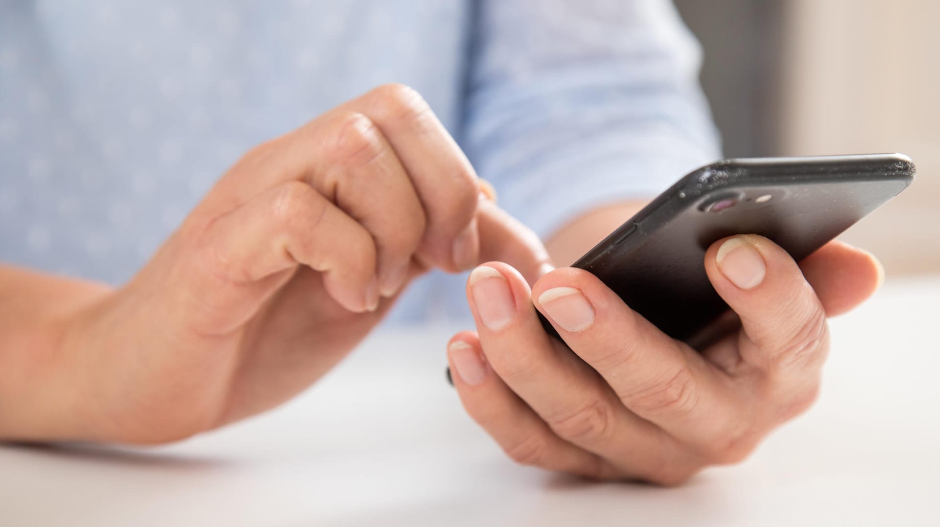 Person tippt auf Smartphone: Aufräumen kann sich beim Handy lohnen.