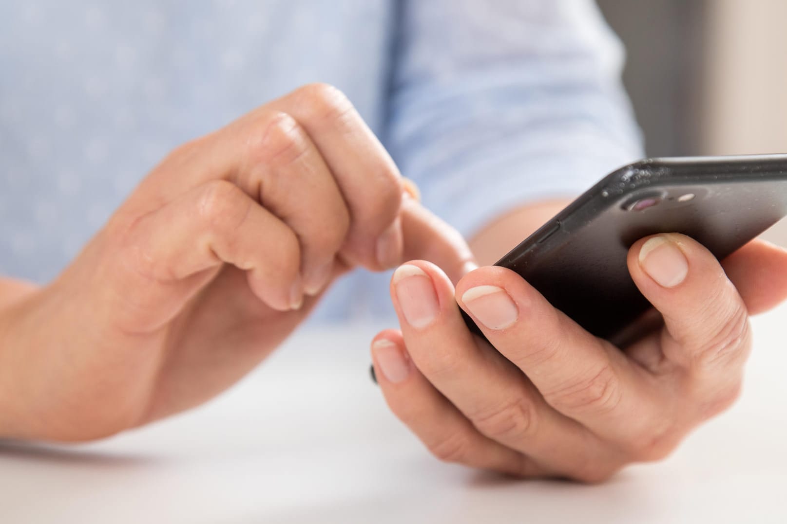 Person tippt auf Smartphone: Aufräumen kann sich beim Handy lohnen.