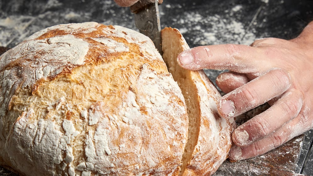 Brot wird geschnitten: Eine bestimmte Frucht nimmt Feuchtigkeit auf und gibt sie langsam ans Brot ab.