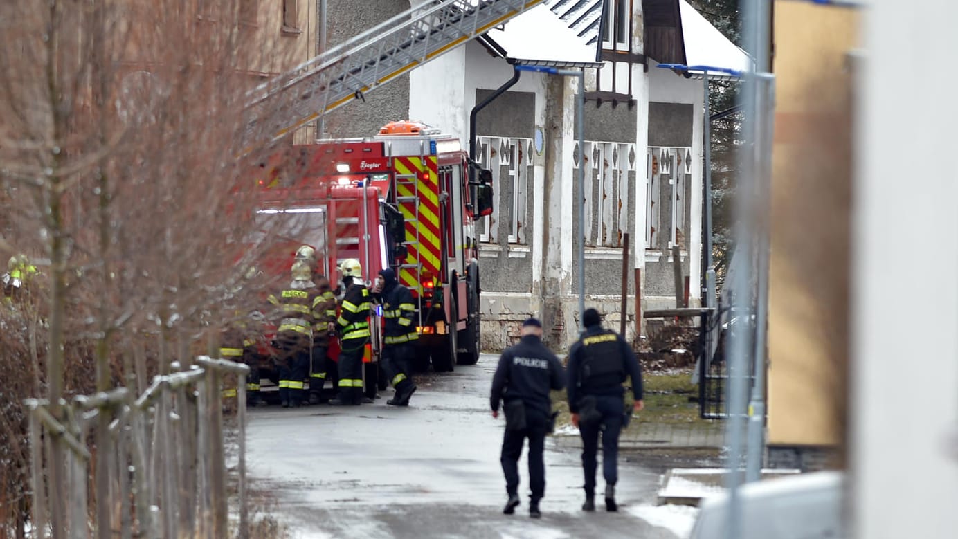 Vejprty: Feuerwehrleute stehen während der Löscharbeiten an einem Einsatzwagen vor einem Pflegeheim für Behinderte. Vejprty: Feuerwehrleute stehen während der Löscharbeiten an einem Einsatzwagen vor einem Pflegeheim für Behinderte.