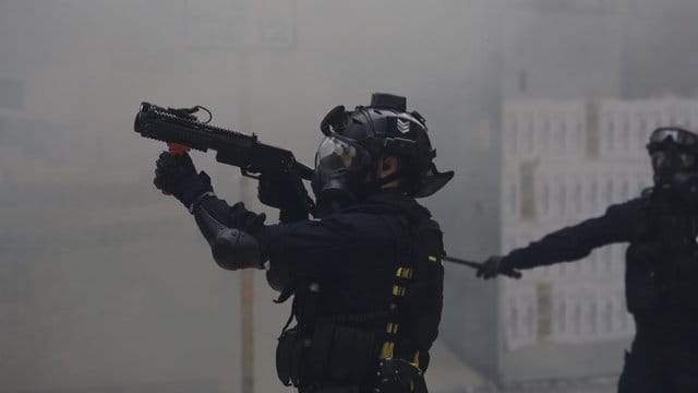 Ein Polizist zielt mit Tränengas auf Demonstranten bei regierungskritischen Protesten. Ein Polizist zielt mit Tränengas auf Demonstranten bei regierungskritischen Protesten.