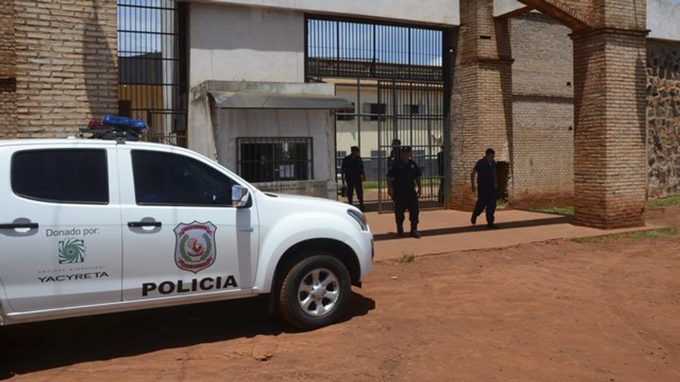 Polizisten stehen vor dem Eingang des Gefängnisses in Paraguay, aus dem bei einem Massenausbruch 75 Häftlinge getürmt sind.