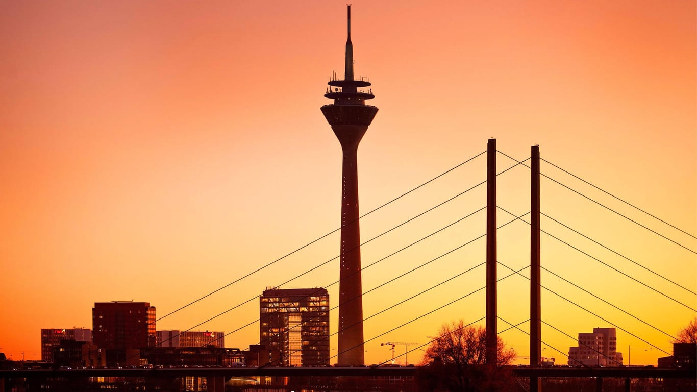 Die Düsseldorfer Skyline mit Stadttor, Rheinturm und Rheinkniebruecke im Abendrot: Zu sehen gibt es in Düsseldorf eine Menge.